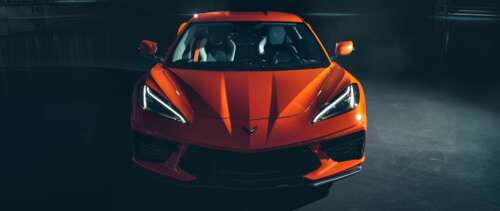 A bright orange Chevrolet Corvette C8 sports car highlighting its sleek aerodynamic... UWUHD computer backgrounds