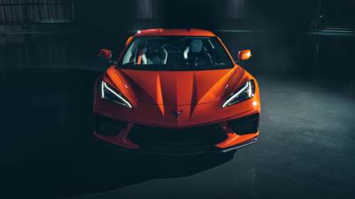 A bright orange Chevrolet Corvette C8 sports car highlighting its sleek aerodynamic...