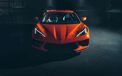 A bright orange Chevrolet Corvette C8 sports car highlighting its sleek aerodynamic...