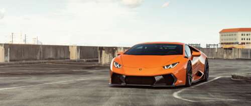 A sleek and polished bright orange Lamborghini Huracan supercar showcasing its aerodynamic... UWUHD ps4 wallpaper
