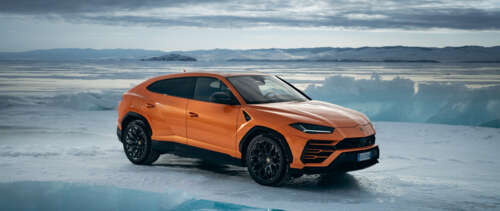 A high-performance bright orange Lamborghini UrUS luxury SUV featuring aggressive...
