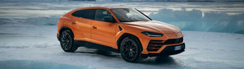 A high-performance bright orange Lamborghini UrUS luxury SUV featuring aggressive... Dual UHD