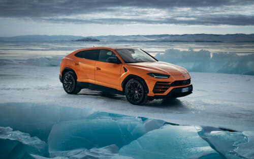 A high-performance bright orange Lamborghini UrUS luxury SUV featuring aggressive... 7680x4800 free desktop wallpaper