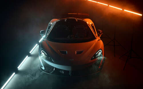A high-performance McLaren 620R supercar in a bright orange finish, showcasing its... 7680x4800 wallpaper for laptop download