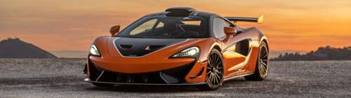 A high-performance McLaren 620R supercar in a striking vibrant orange color. Dual UHD free wallpaper