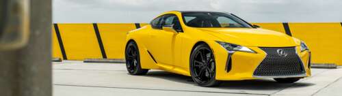 A sleek and vibrant yellow Lexus LC 500 supercar featuring aerodynamic luxury styling. Dual UHD hd background