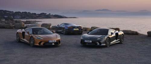 Two McLaren GT supercars parked together, one in metallic silver and one in bright... UWUHD wallpaper download