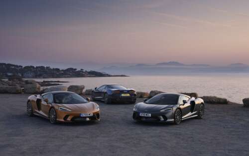 Two McLaren GT supercars parked together, one in metallic silver and one in bright... 7680x4800 wallpaper