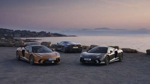 Two McLaren GT supercars parked together, one in metallic silver and one in bright... 8K wallpaper