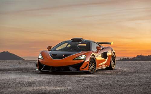 A high-performance McLaren 620R supercar in a striking vibrant orange color. 7680x4800 free wallpaper