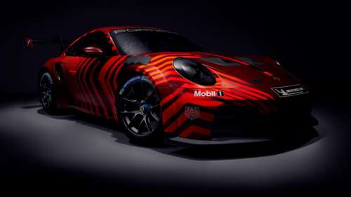 A cinematic 5K view of the 2025 Porsche 911 GT3 Cup racing car emerging from a dark,... wallpaper