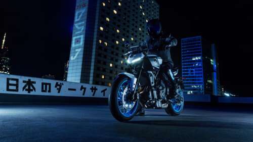A sleek 2025 Yamaha MT-07 naked motorcycle parked on a city street under night lights.