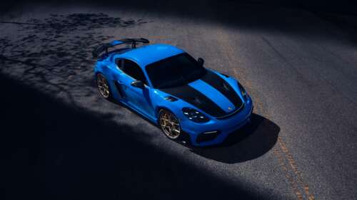 Close-up of a blue Porsche 718 Cayman GT4 RS featuring racing stripes wallpaper