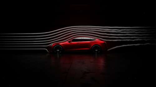 A sleek red car positioned against a dark, minimalist background representing a futuristic... wallpaper for laptop download