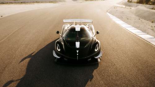 A futuristic Koenigsegg hypercar, Sadair's Spear, driving on an asphalt racing circuit. wallpaper