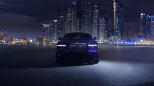 A luxurious Rolls-Royce Black Badge Spectre driving through the neon-lit streets... wallpaper download