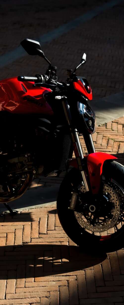 A sleek and aggressive 2026 Ducati Monster V2 motorcycle featuring modern sports... Samsung Galaxy Z Flip7 FE download free phone wallpaper