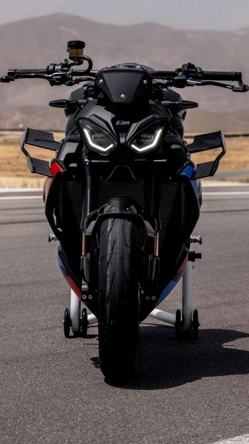 A high-detail shot of the 2026 BMW M 1000 R motorcycle parked on asphalt. Apple iPhone SE 2022 pictures for wallpaper