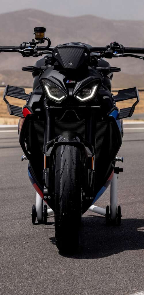 A high-detail shot of the 2026 BMW M 1000 R motorcycle parked on asphalt. Huawei Mate 30 Pro free wallpaper