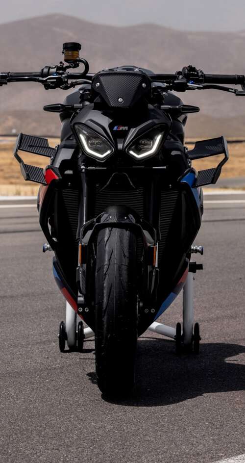 A high-detail shot of the 2026 BMW M 1000 R motorcycle parked on asphalt. Sharp Aquos C10 free wallpaper