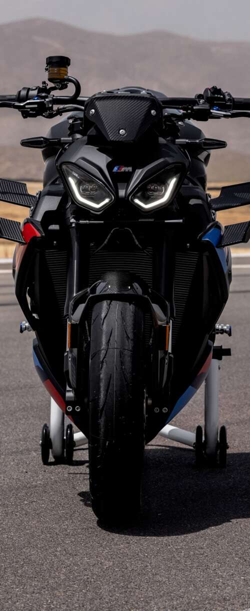 A high-detail shot of the 2026 BMW M 1000 R motorcycle parked on asphalt. Samsung Galaxy Z Flip7 FE wallpaper download