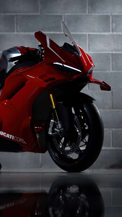 A sleek, red 2026 Ducati Panigale V4 R performance motorcycle with aerodynamic bodywork. Apple iPhone SE 2022 lock screen wallpaper
