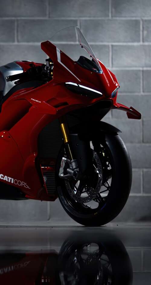 A sleek, red 2026 Ducati Panigale V4 R performance motorcycle with aerodynamic bodywork. Sharp Aquos C10 wallpaper images
