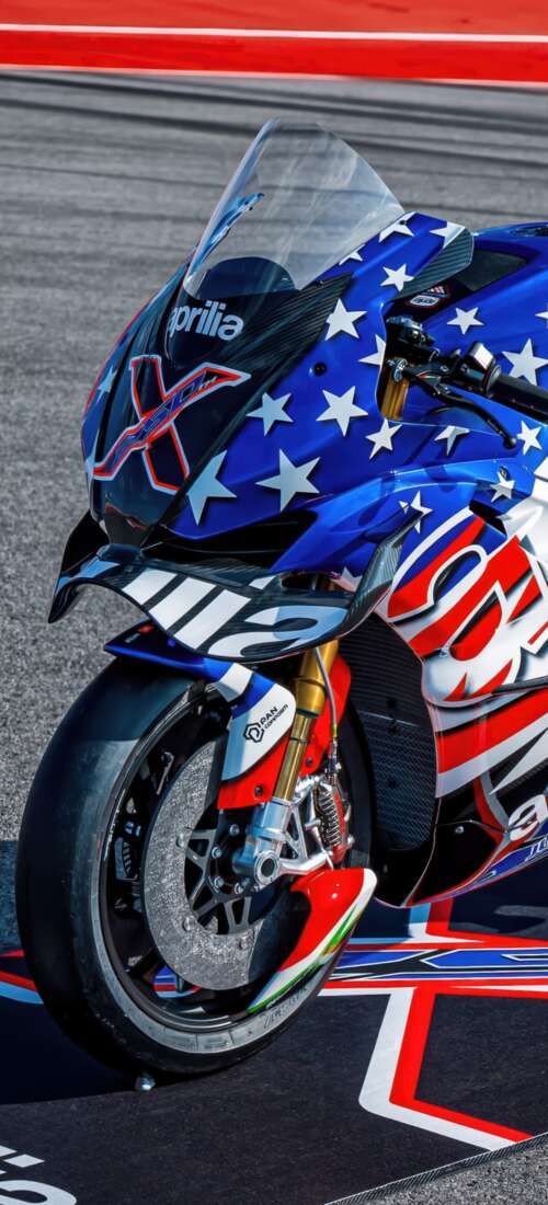Advanced MotoGP racing motorcycles speeding through a corner on a professional circuit... Oppo Find X9 wallpaper download