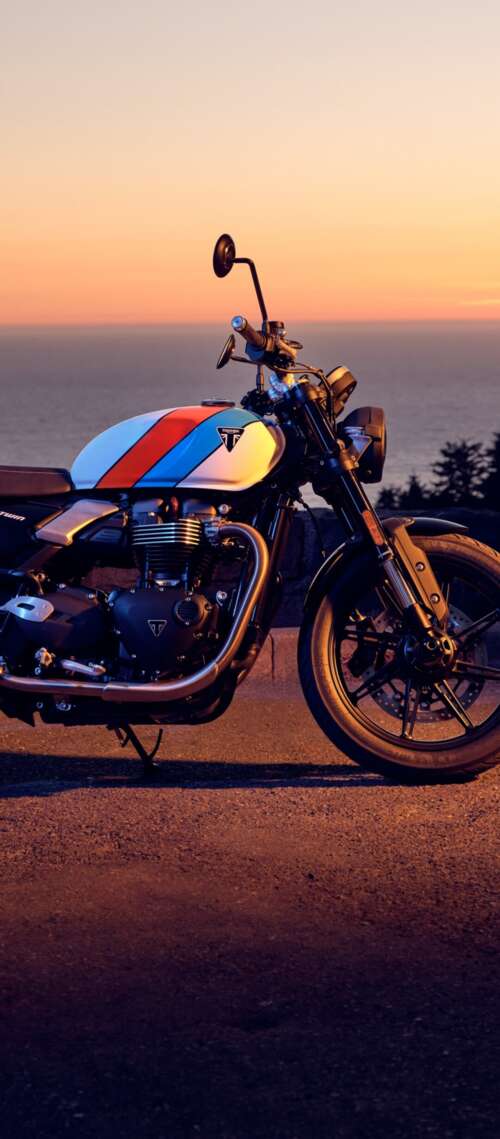 A modern 2025 motorcycle parked against a vibrant sunset sky with warm orange and... Blackview XPLORE X1 hd background