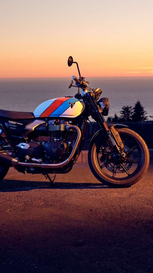 A modern 2025 motorcycle parked against a vibrant sunset sky with warm orange and... Apple iPhone SE 2022 wallpapers for android