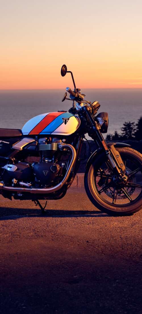 A modern 2025 motorcycle parked against a vibrant sunset sky with warm orange and... Huawei Pura 90 Pro wallpaper