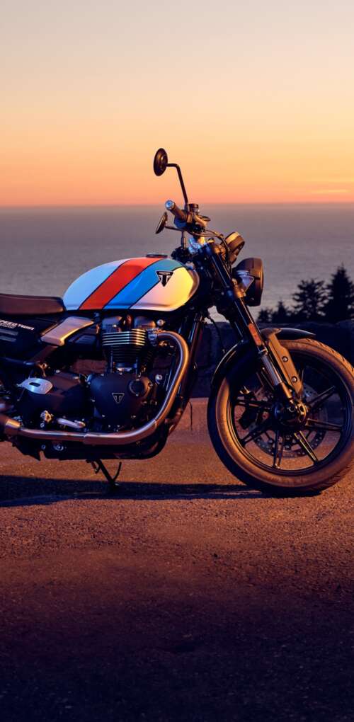 A modern 2025 motorcycle parked against a vibrant sunset sky with warm orange and... Huawei Mate 30 Pro hd background