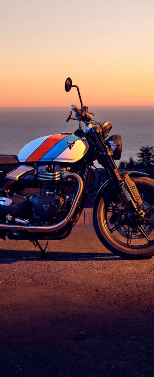 A modern 2025 motorcycle parked against a vibrant sunset sky with warm orange and... Samsung Galaxy Z Flip7 FE wallpaper photo gallery download