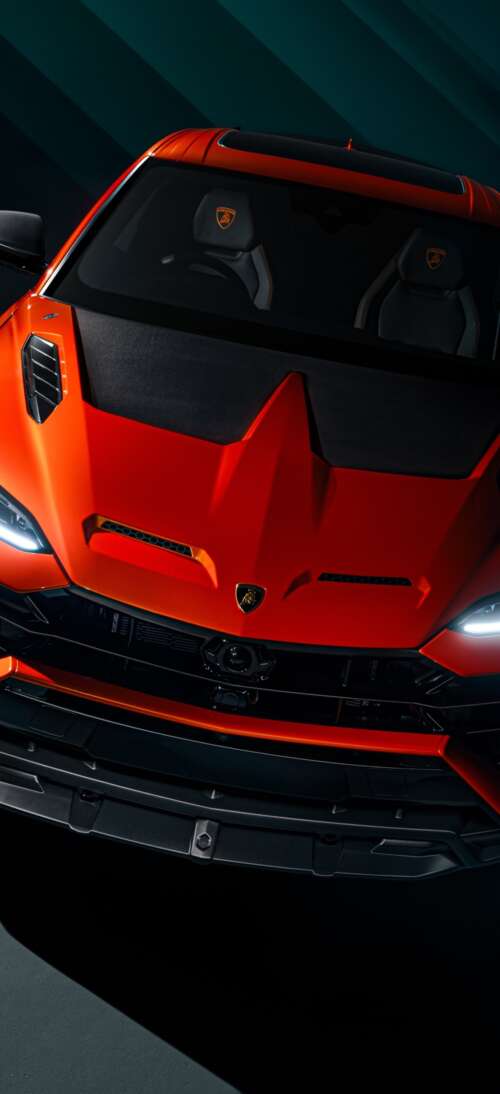 A sleek, dark luxury sports car parked on a city street at night with subtle reflections... realme GT 7T free wallpaper