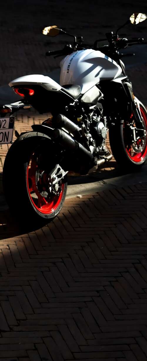 A sleek and futuristic 2026 Ducati Monster V2 sports motorcycle in a high-quality... wallpaper images