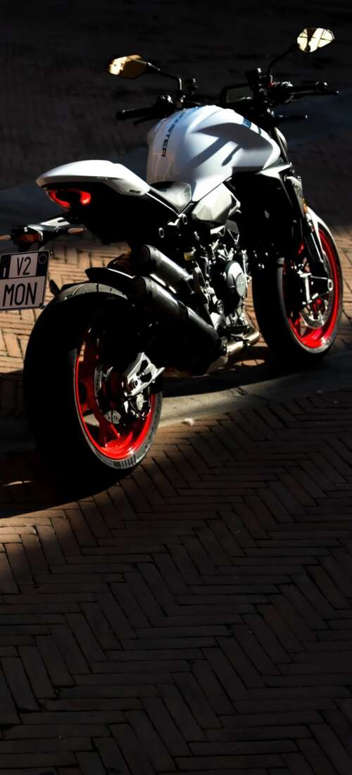A sleek and futuristic 2026 Ducati Monster V2 sports motorcycle in a high-quality... Oppo Find X9
