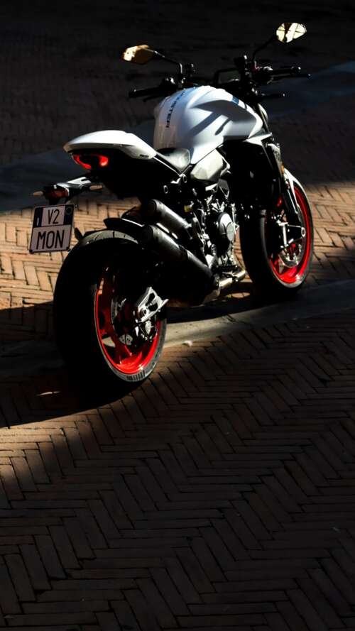 A sleek and futuristic 2026 Ducati Monster V2 sports motorcycle in a high-quality... Apple iPhone SE 2022 lock screen wallpaper
