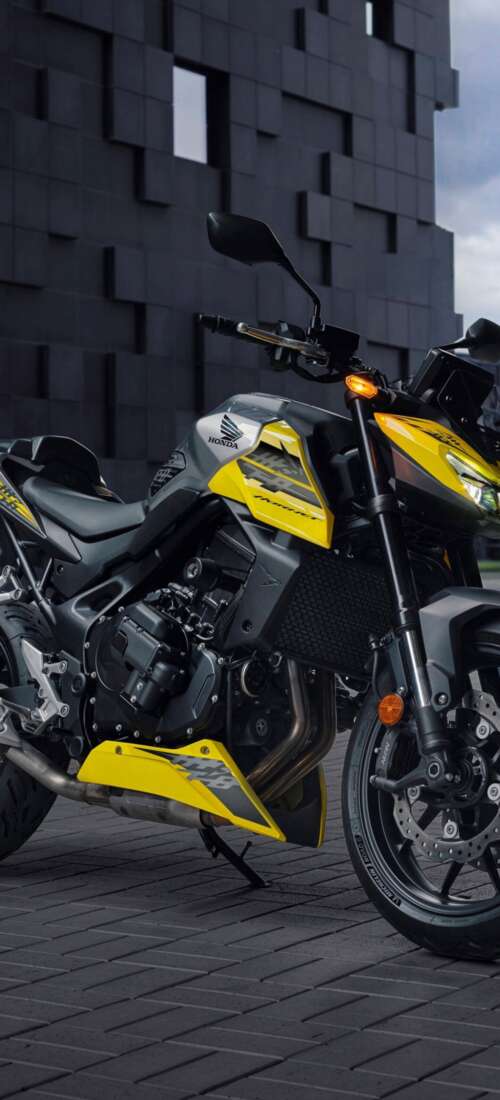 A modern 2026 Honda CB750 Hornet motorcycle parked outdoors in a contemporary landscape. Honor X70 high definition wallpaper