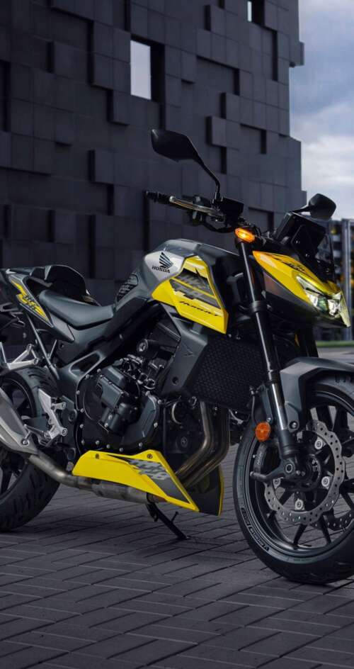A modern 2026 Honda CB750 Hornet motorcycle parked outdoors in a contemporary landscape. Sharp Aquos C10 high definition wallpaper