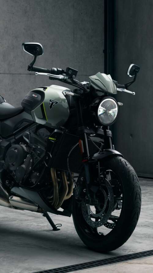 A muscular black Triumph Trident 660 street motorcycle with a sleek, modern design. hd background