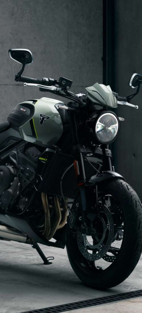 A muscular black Triumph Trident 660 street motorcycle with a sleek, modern design. Honor X70 mobile wallpaper