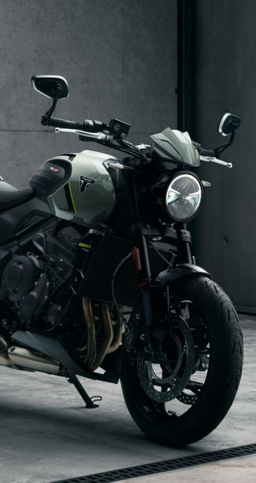 A muscular black Triumph Trident 660 street motorcycle with a sleek, modern design. Sharp Aquos C10 hd background