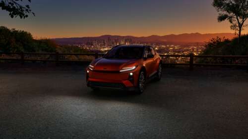 A sleek 2026 Toyota C-HR hybrid car parked under a vibrant sunset sky with golden... wallpaper