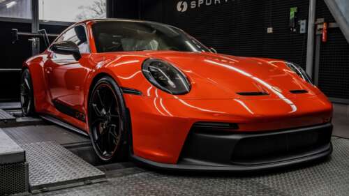 A high-resolution, detailed shot of a bright orange Porsche 911 GT3 Clubsport racing... wallpaper