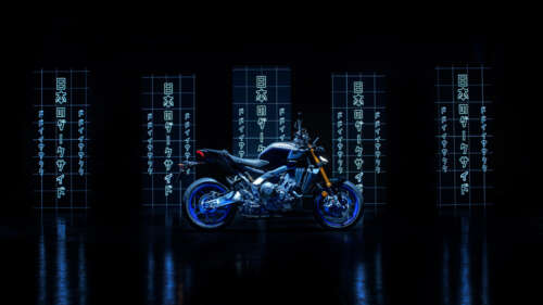 A sleek 2024 Yamaha MT-09 motorcycle with vibrant lighting details against a pitch-black... wallpaper