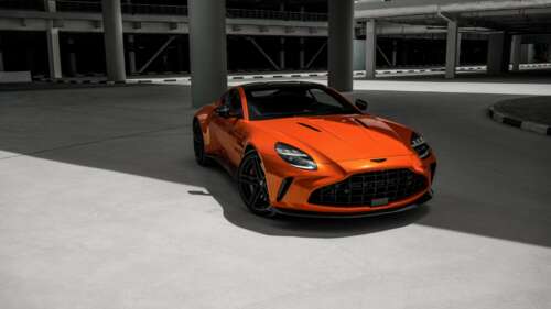A vibrant orange 2025 Aston Martin Vantage luxury sports car shown in high detail. wallpaper