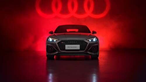 A high-detail shot of an Audi RS 5 Sportback against a vivid red aesthetic background. wallpaper