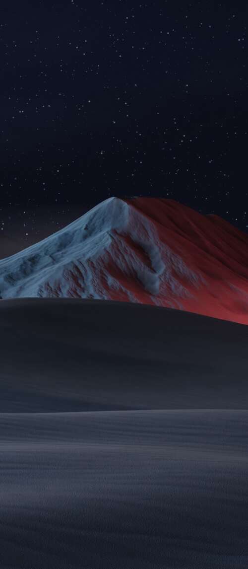 A dramatic night landscape featuring snow-capped mountains, sand dunes, and a starry... wallpaper