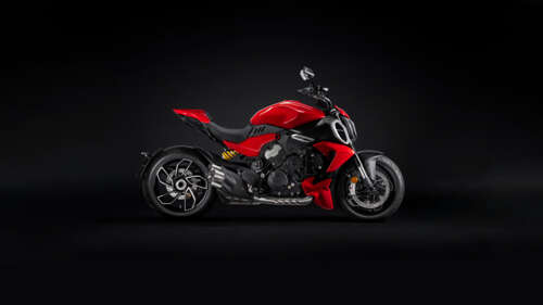 A vibrant red Ducati Diavel V4 motorcycle positioned against a dark, atmospheric... free wallpaper