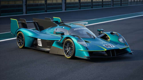 A sleek 2025 Le Mans Hypercar hybrid sports car driving fast on a smooth asphalt... wallpaper